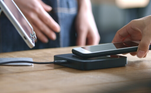 スマートフォンによる非接触型電子決済の様子。AI・IoT技術を活用し、高度な決済セキュリティを備えた次世代キャッシュレス決済システムを支援。流通業界やクレジットカード業界向けに安全で利便性の高い決済ソリューションを提供。