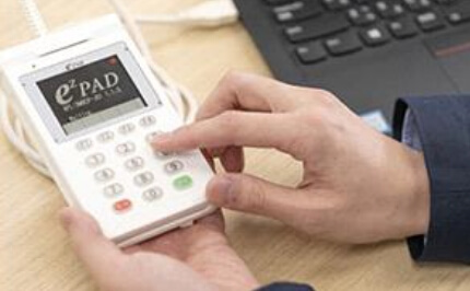 Image of a multi-payment terminal installed at a store cash register. Provides payment solutions that support credit, debit, UnionPay, EMV, multi-currency payment, loyalty point service, and QR code payment to realize comfortable cashless payment.