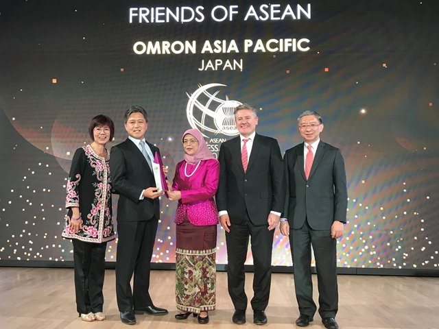 Singapore President Halimah Yacob (center) presents a memorial shield to OMRON Management Center of Asia-Pacific President, Yutaka Iitaka (second from left)